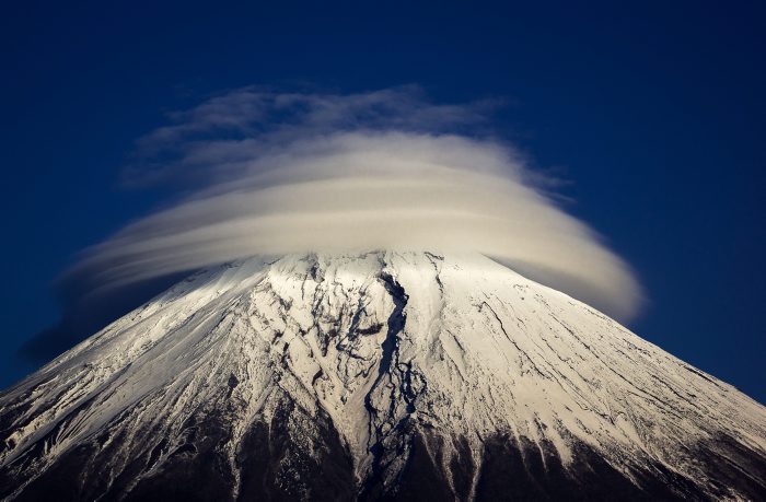 This bizarre cloud formation has formed rings round the top of a mountain. The lenticular cloud sits atop the towering Mount Fuji, in Japan, during an otherwise blue skied day. The lens-shaped clouds are formed at high altitudes, when a moist air flow encounters obstructions - such as mountains or buildings - which disrupt the air flow and create standing waves in the atmosphere. These waves form on the downwind side and as the moisture in the air condenses, it forms these odd-shaped clouds. Photographer Akihiro Shibata spotted the clouds circling the top of Mount Fuji, which is the highest mountain in Japan at 3,776m, while at Yamanashi Prefecture Lake Tanuki, in Fujinomiya, Japan. The 41-year-old, from Matsumoto, Nagano Prefecture, in Japan, said: "It was a beautiful cloud formation. "I couldn't resist taking some photos even though I was actually there to take photographs of something else". (Akihiro Shibata/Solent News/REX )